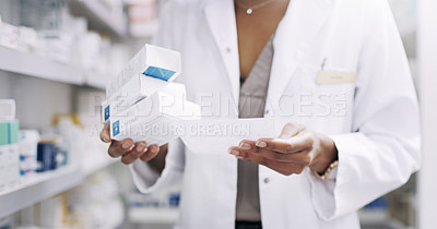 Buy stock photo Cropped shot of an unrecognizable young pharmacist looking at a prescription in a chemist