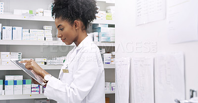 Buy stock photo Cropped shot of an attractive  young pharmacist using a digital tablet in a chemist