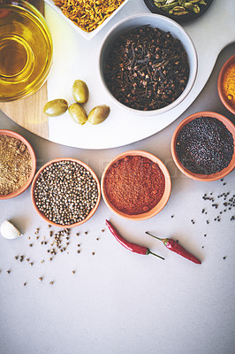 Buy stock photo Bowl, seasoning and board in gray background for spices, powder and sensory appeal for creativity with culinary. Studio, condiment and curry for cooking with clove, aroma and ingredients collection