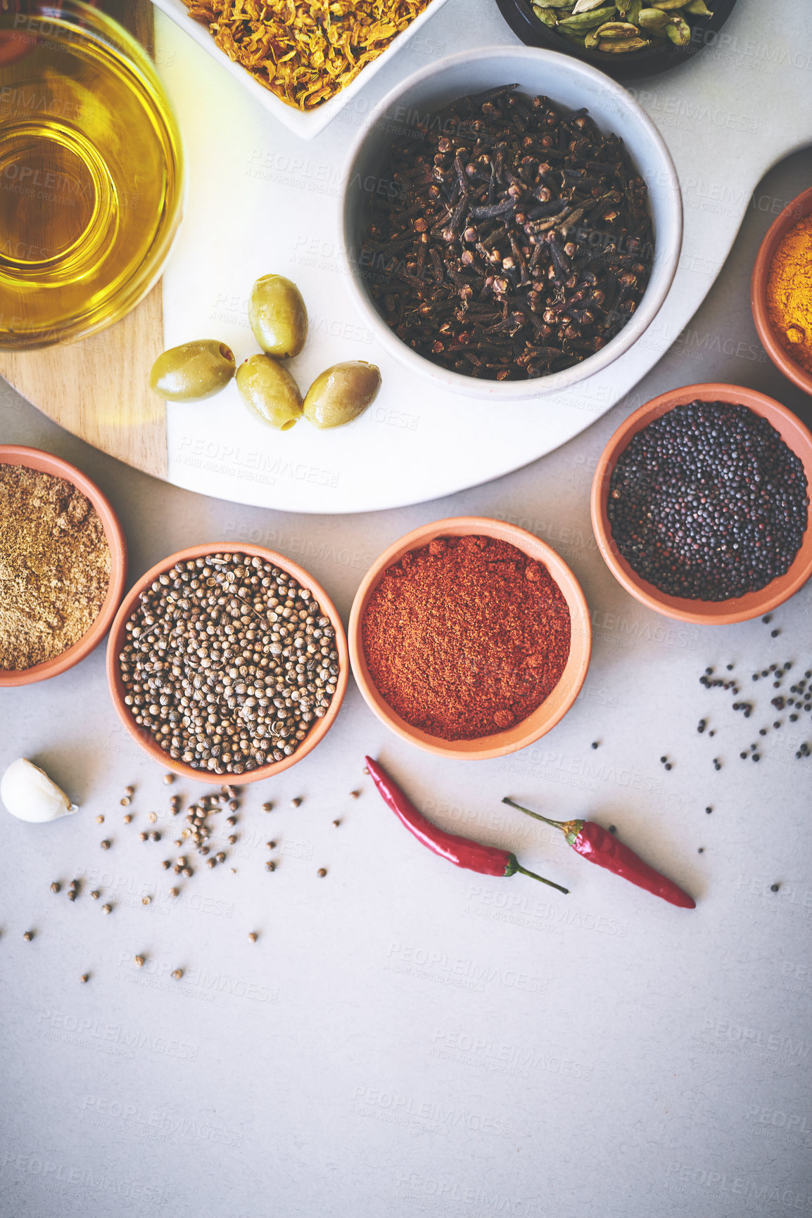 Buy stock photo Bowl, seasoning and board in gray background for spices, powder and sensory appeal for creativity with culinary. Studio, condiment and curry for cooking with clove, aroma and ingredients collection