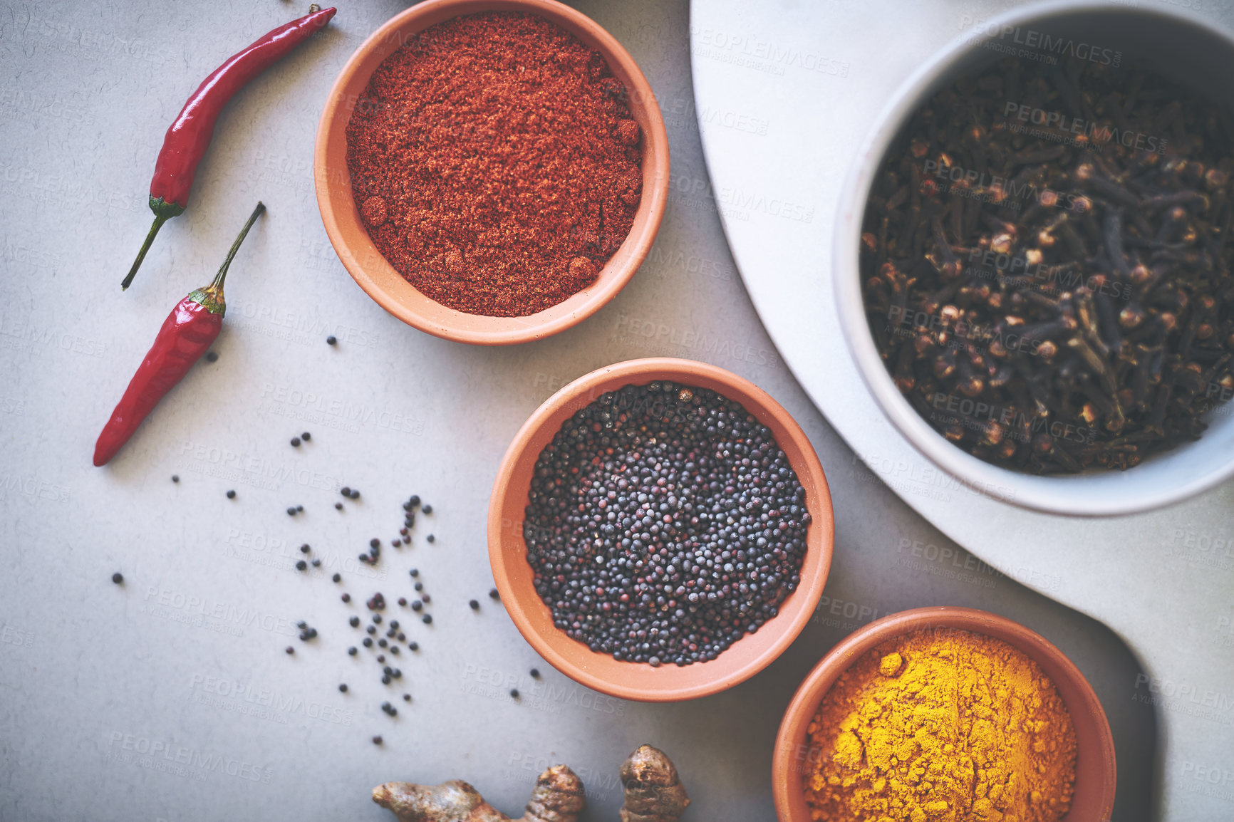 Buy stock photo Bowl, clove and board in gray background for spices, powder and sensory appeal for creativity with culinary. Studio, condiment and flavor for cooking with ingredients, aroma and seasoning collection