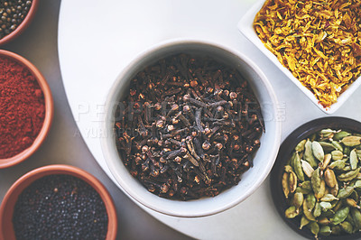 Buy stock photo Above, bowl and clove in gray background for spices, powder and variety for sensory appeal with culinary. Studio, condiment and flavor for cooking with ingredients, texture and seasoning collection