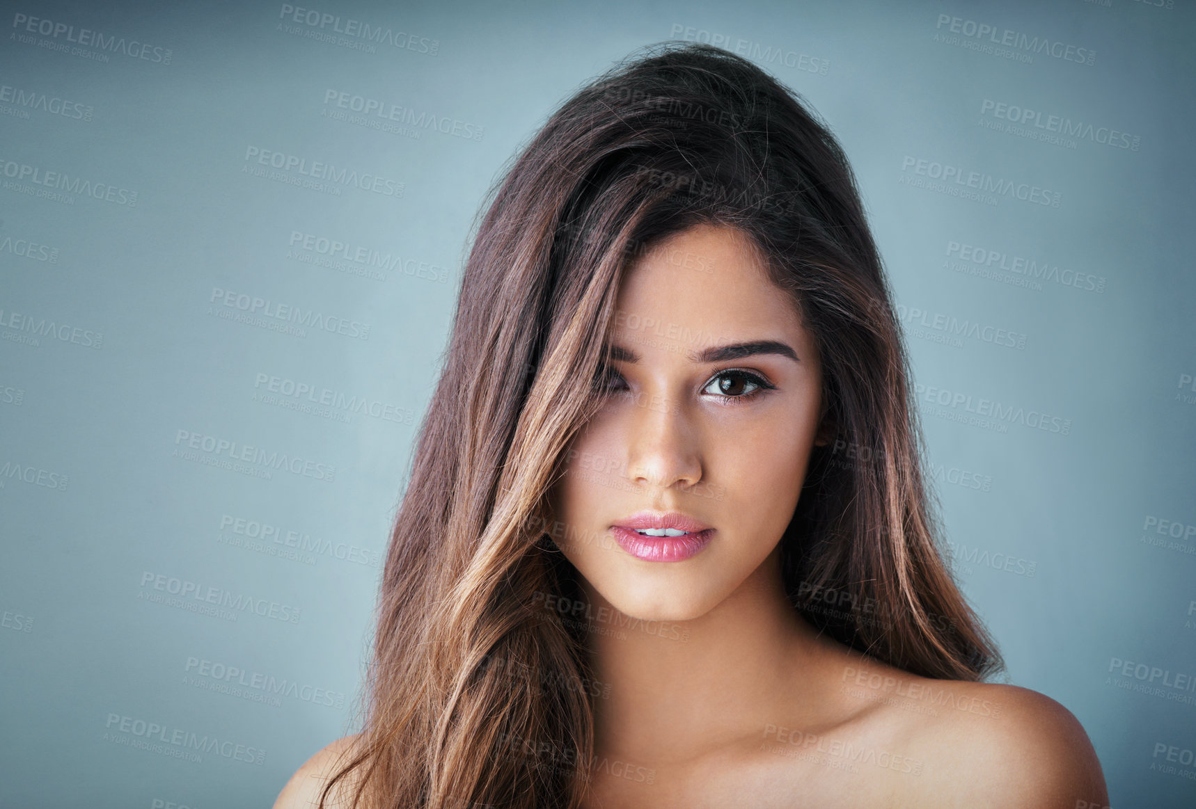 Buy stock photo Studio portrait of a beautiful young woman posing against a gray background