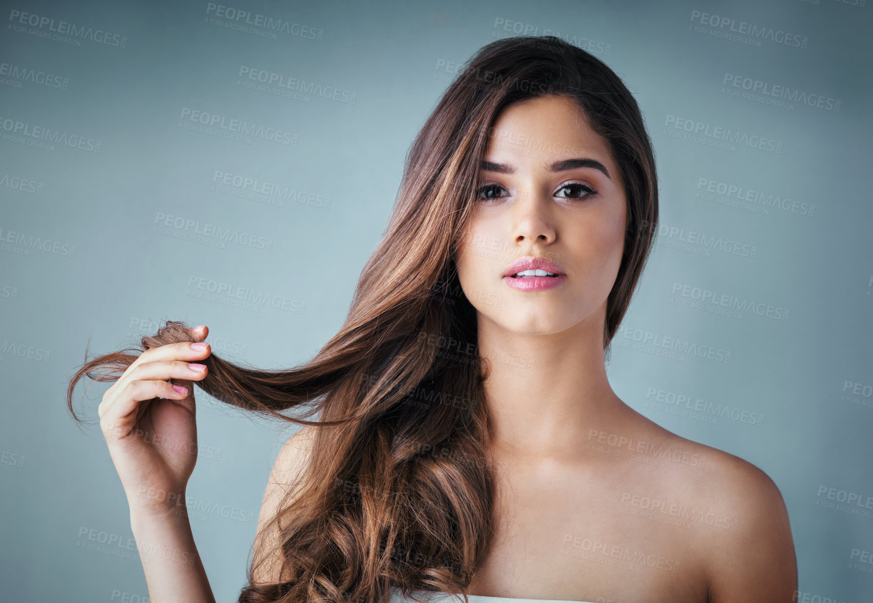 Buy stock photo Studio portrait of a beautiful young woman posing against a gray background