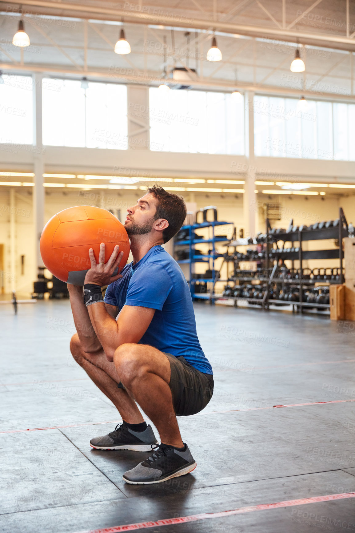 Buy stock photo Full length shot of a handsome young man working out with a medicine ball in the gym