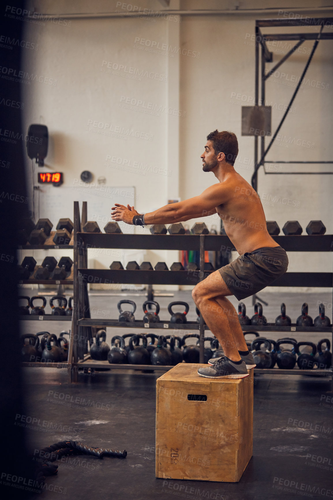 Buy stock photo Full length shot of a handsome young man box jumping while working out in the gym