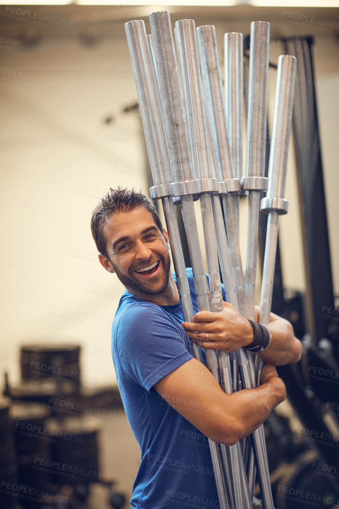 Buy stock photo Cropped portrait of a handsome young man carrying equipment while working out in the gym
