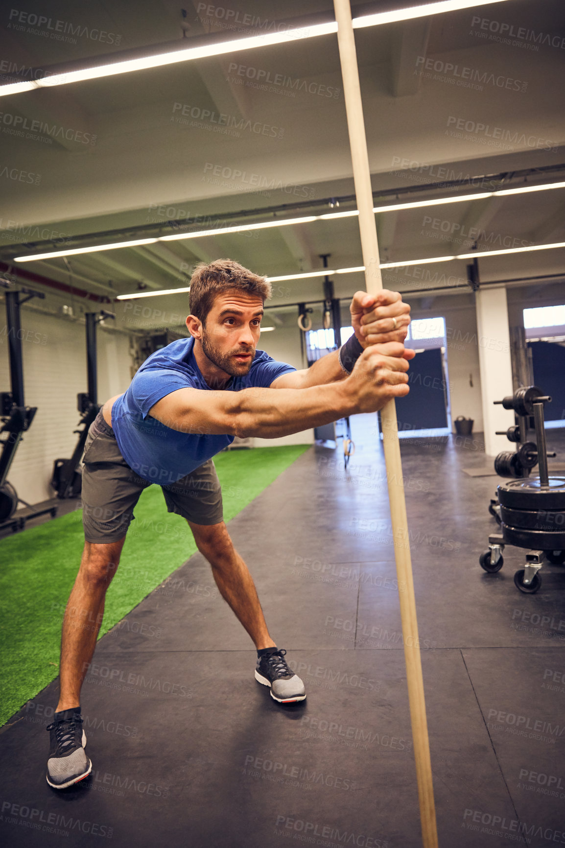 Buy stock photo Full length shot of a handsome young man working out with a stick in the gym