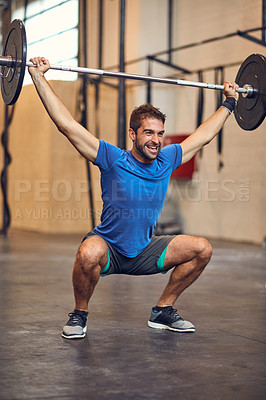 Buy stock photo Full length shot of a handsome young man lifting weights while working out in the gym