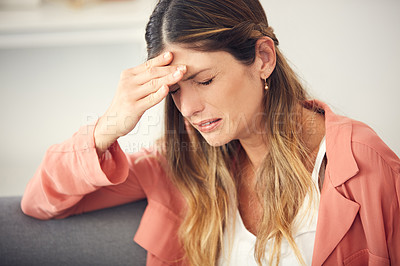 Buy stock photo Cropped shot of a young woman looking upset while sitting at home