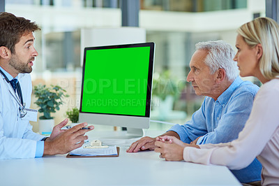 Buy stock photo Shot of a doctor discussing findings on his computer with a senior man and his daughter at the clinic