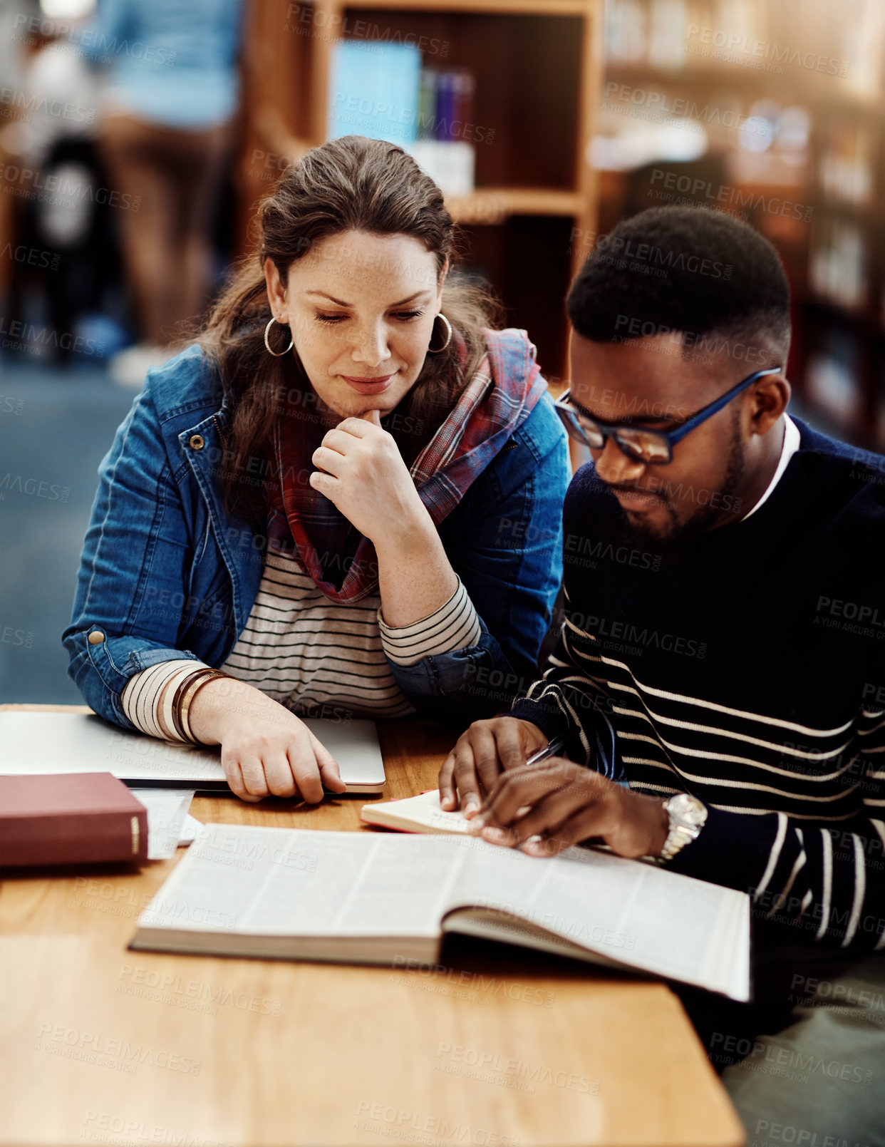 Buy stock photo Shot of a group of university students working in the library at campus