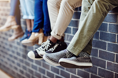 Buy stock photo Brick wall, student feet and friends outdoor on university campus together with sneakers. Relax, urban youth and foot at college with people legs ready for education, study and shoes while sitting