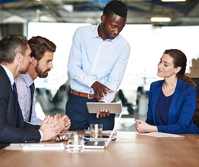 Buy stock photo Shot of a group of businesspeople discussing something on a digital tablet