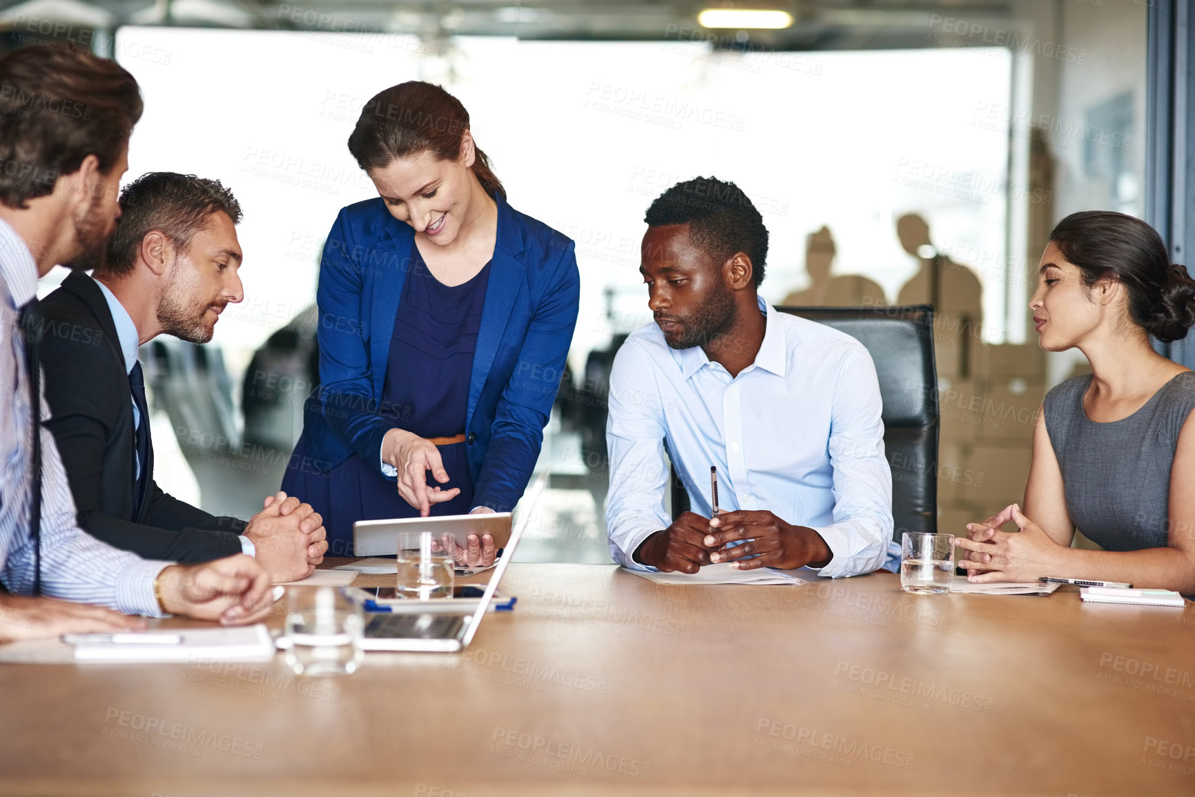 Buy stock photo Shot of a group of businesspeople discussing something on a digital tablet