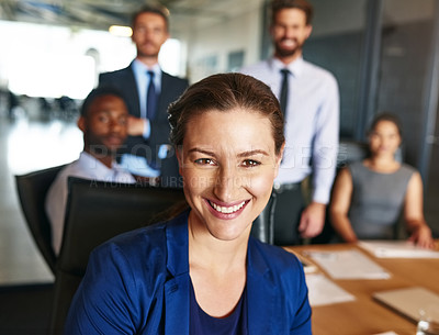 Buy stock photo Portrait of a smiling businesswoman sitting in an office with colleagues in the background