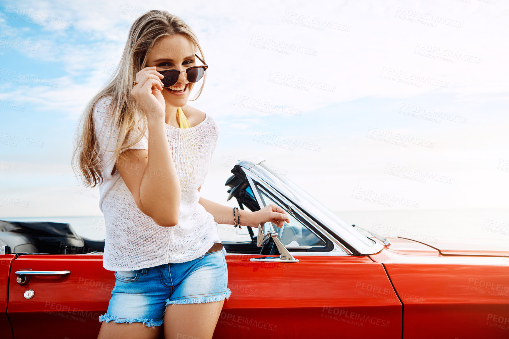 Buy stock photo Shot of a happy young woman enjoying a summer’s road trip