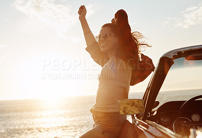 Buy stock photo Shot of a happy young woman enjoying a summer’s road trip