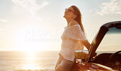 Buy stock photo Shot of a happy young woman enjoying a summer’s road trip