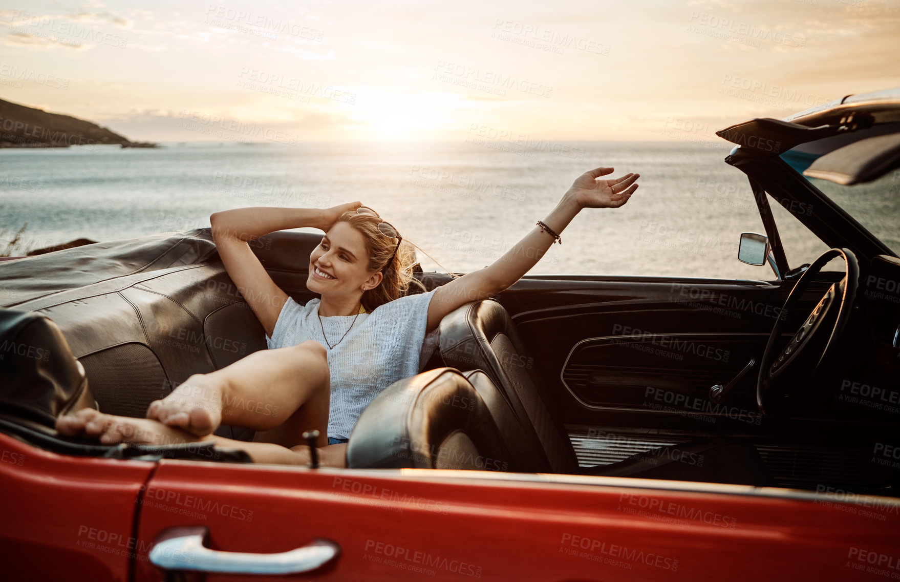 Buy stock photo Shot of a happy young woman enjoying a summer’s road trip