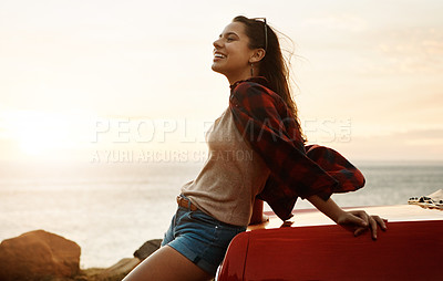 Buy stock photo Shot of a happy young woman enjoying a summer’s road trip