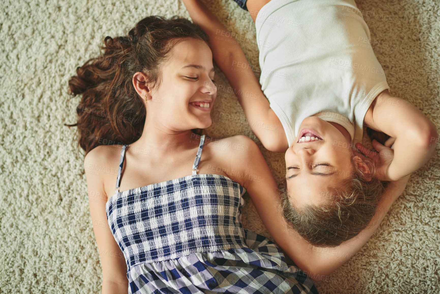 Buy stock photo Sisterhood, girl kids and happy in home with bonding, playing together and protection in relationship. Top view, people and siblings on floor for relax, enjoying weekend and laughing for funny joke