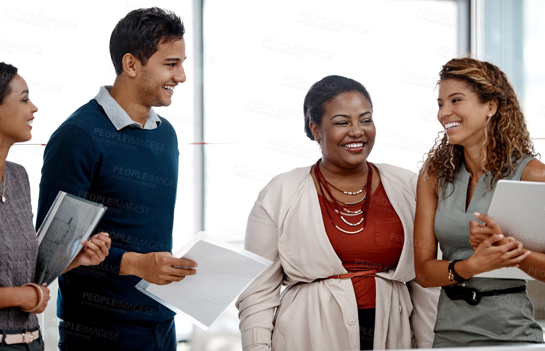 Buy stock photo Cropped shot of a young diverse group of colleagues sharing a laugh together in the office