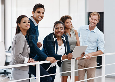 Buy stock photo Shot of a confident group of colleagues standing together in the office and smiling at the camera