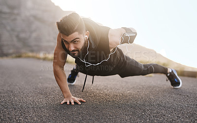 Buy stock photo Shot of a sporty young man doing pushups while exercising outdoors