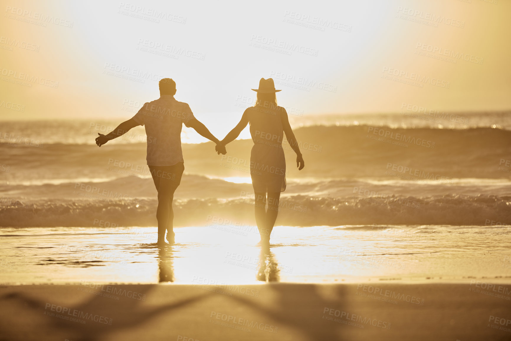 Buy stock photo Rearview shot of a mature couple spending quality time on the beach