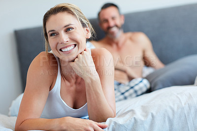 Buy stock photo Cropped shot of an attractive young woman looking happy in the bedroom with her husband in the background