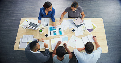 Buy stock photo Top view, planning and group of business people in meeting, discussion or brainstorming in creative startup. Above, team and conversation at table with documents, laptop or tablet of graphic designer