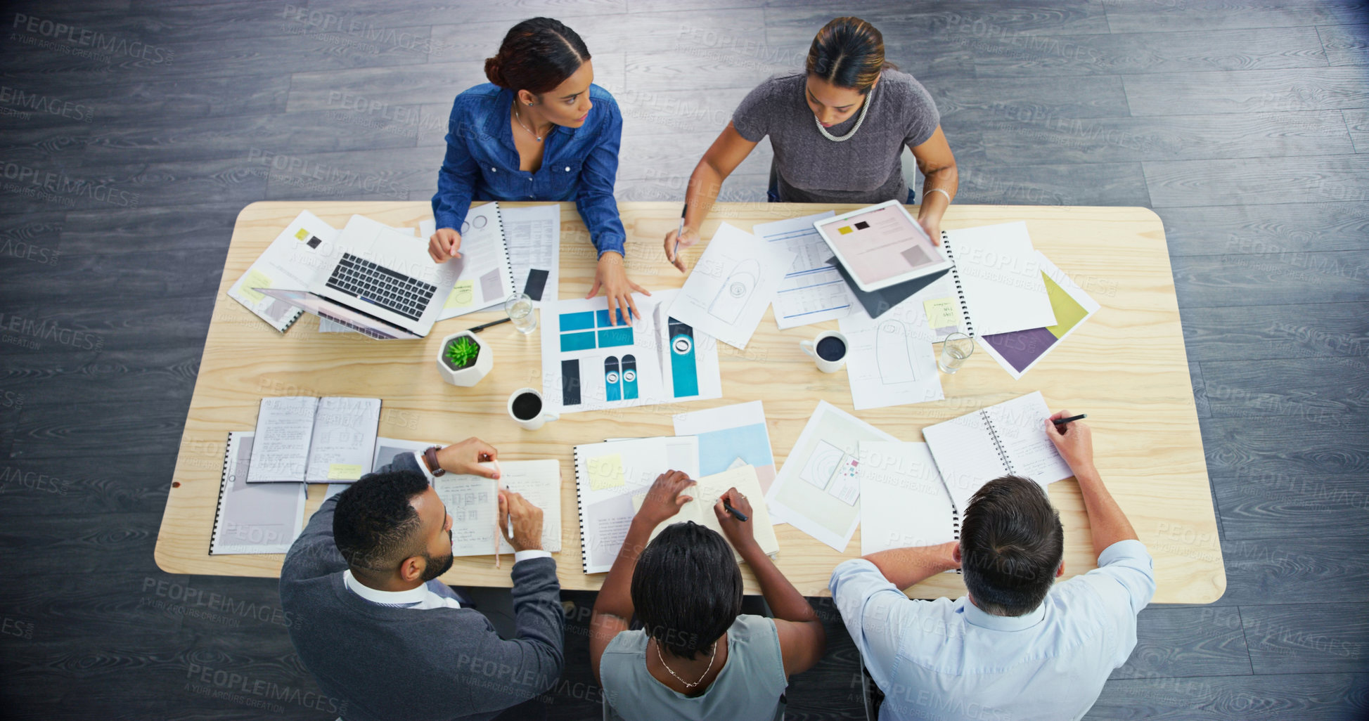 Buy stock photo Top view, planning and group of business people in meeting, discussion or brainstorming in creative startup. Above, team and conversation at table with documents, laptop or tablet of graphic designer