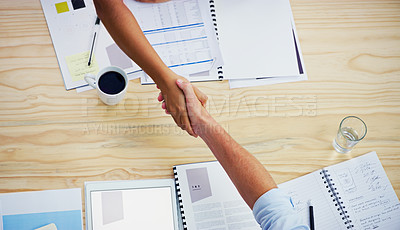 Buy stock photo High angle shot of two businesspeople shaking hands during a meeting at work