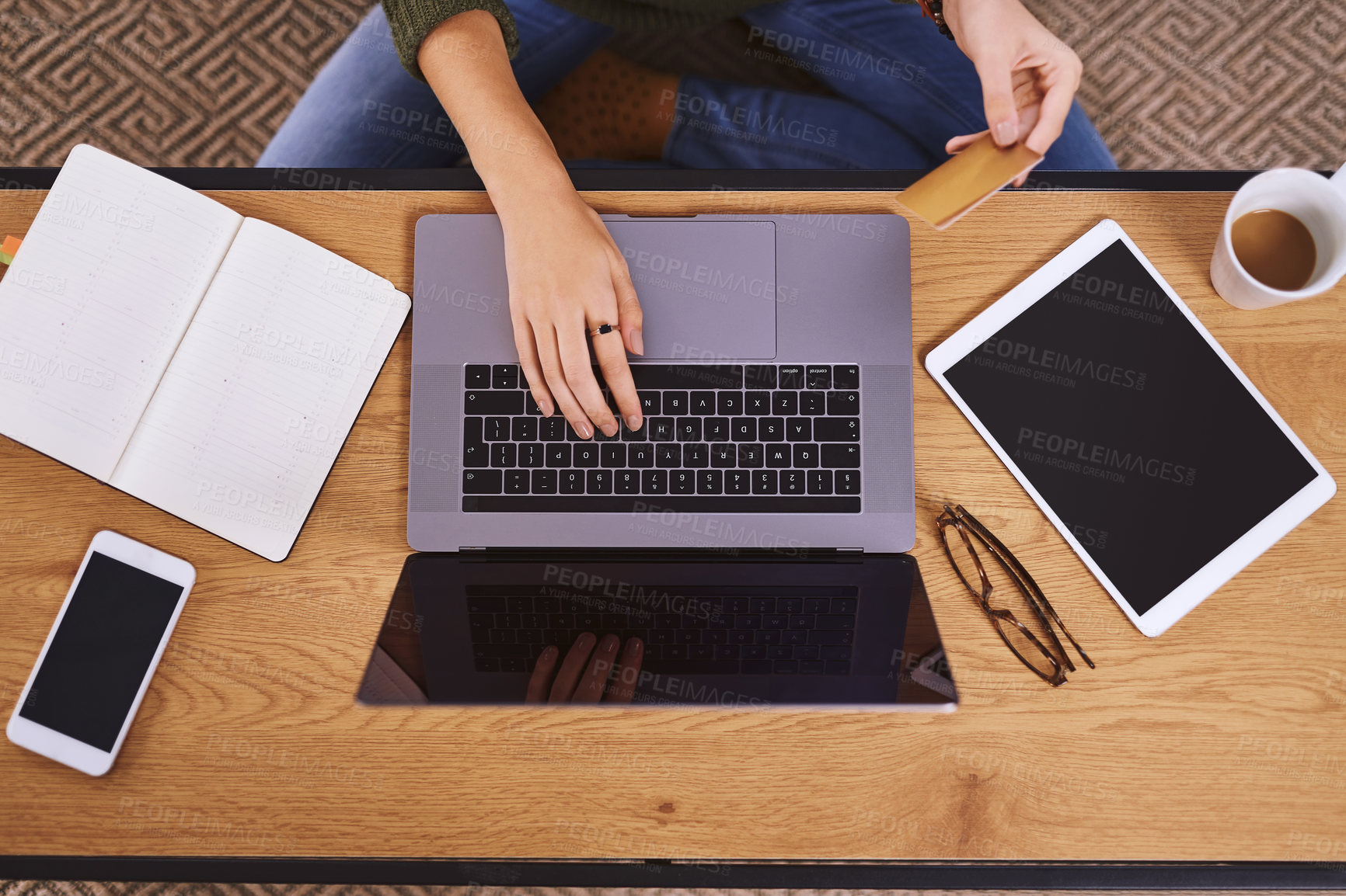 Buy stock photo High angle shot of an unrecognizable woman using a laptop and credit card to do some online shopping at home