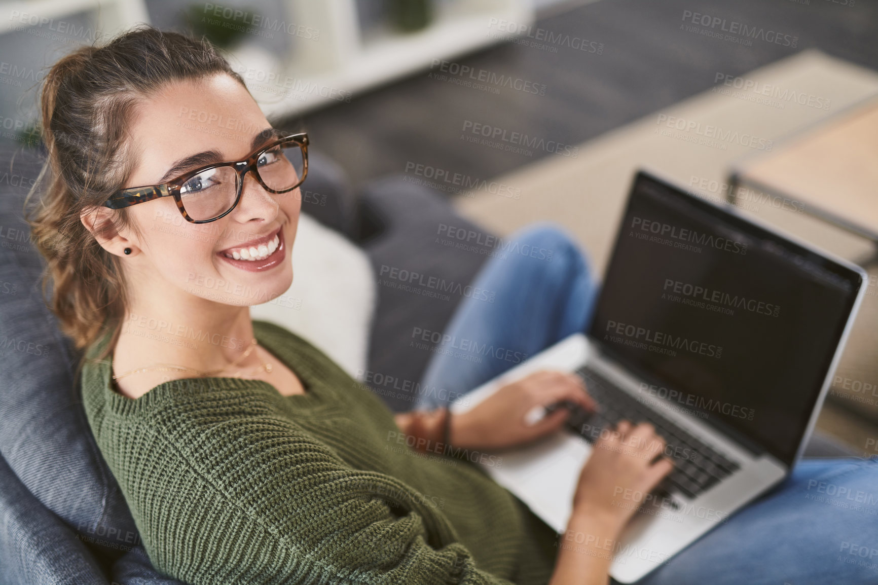 Buy stock photo Portrait of a beautiful young woman using her laptop while relaxing on a couch at home
