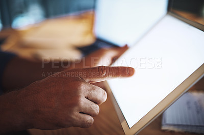Buy stock photo Shot of an unrecognisable businessman working late at night on his tablet in a modern office