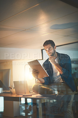 Buy stock photo Shot of a businessman using a digital tablet in his office