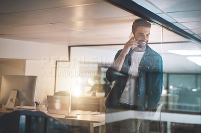Buy stock photo Cropped shot of a businessman talking on his cellphone while standing in his office