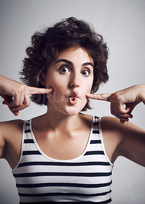 Buy stock photo Studio portrait of an attractive young woman making a funny face against a grey background
