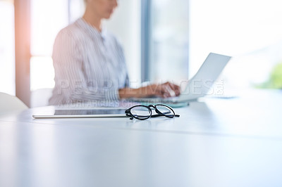 Buy stock photo Shot of an unrecognizable businesswoman working on a laptop in her office