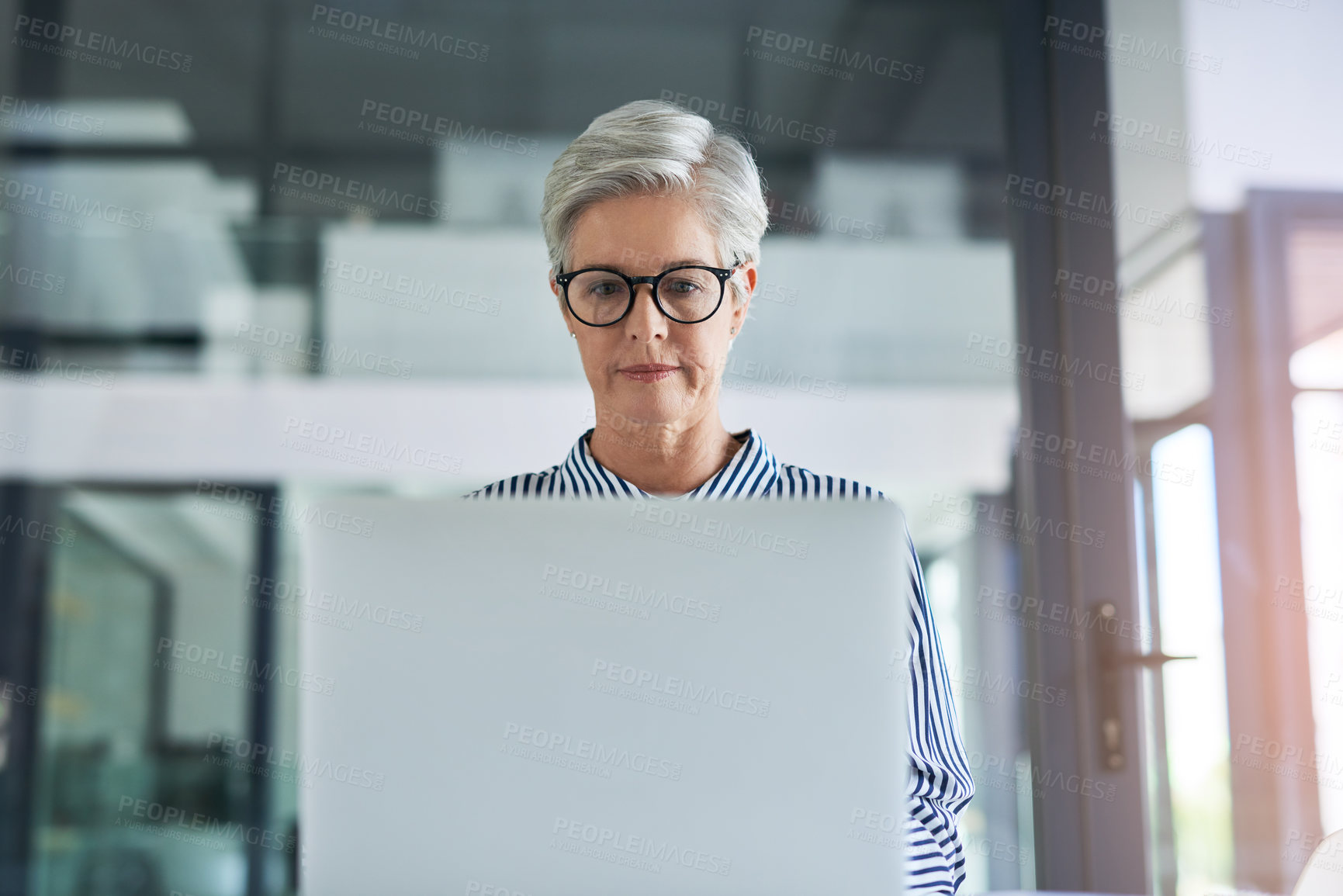 Buy stock photo Shot of an attractive mature woman working on laptop in her office