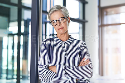 Buy stock photo Portrait of an attractive mature businesswoman posing with her arms folded in her office