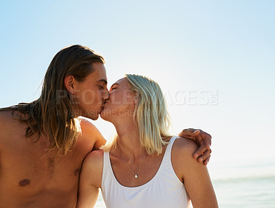 Buy stock photo Shot of an affectionate young couple kissing each other at the beach