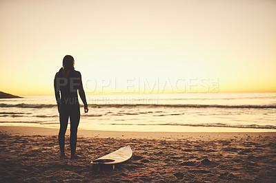 Buy stock photo Rearview shot of a young surfer looking towards the ocean at the beach