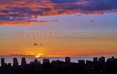 Buy stock photo Landscape view of a city skyline at sunset in Waikiki, Oahu, Hawaii, USA. Beautiful cityscape and a vibrant blue and orange sky with clouds and copy space. Sun setting over a sea horizon