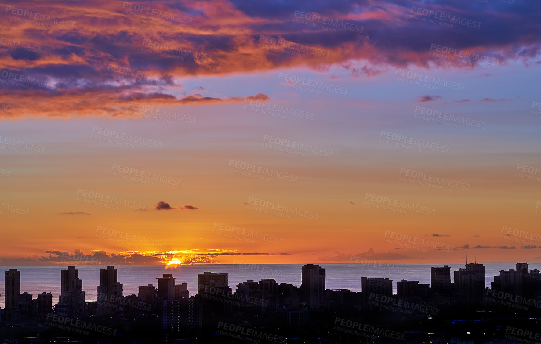 Buy stock photo Landscape view of a city skyline at sunset in Waikiki, Oahu, Hawaii, USA. Beautiful cityscape and a vibrant blue and orange sky with clouds and copy space. Sun setting over a sea horizon