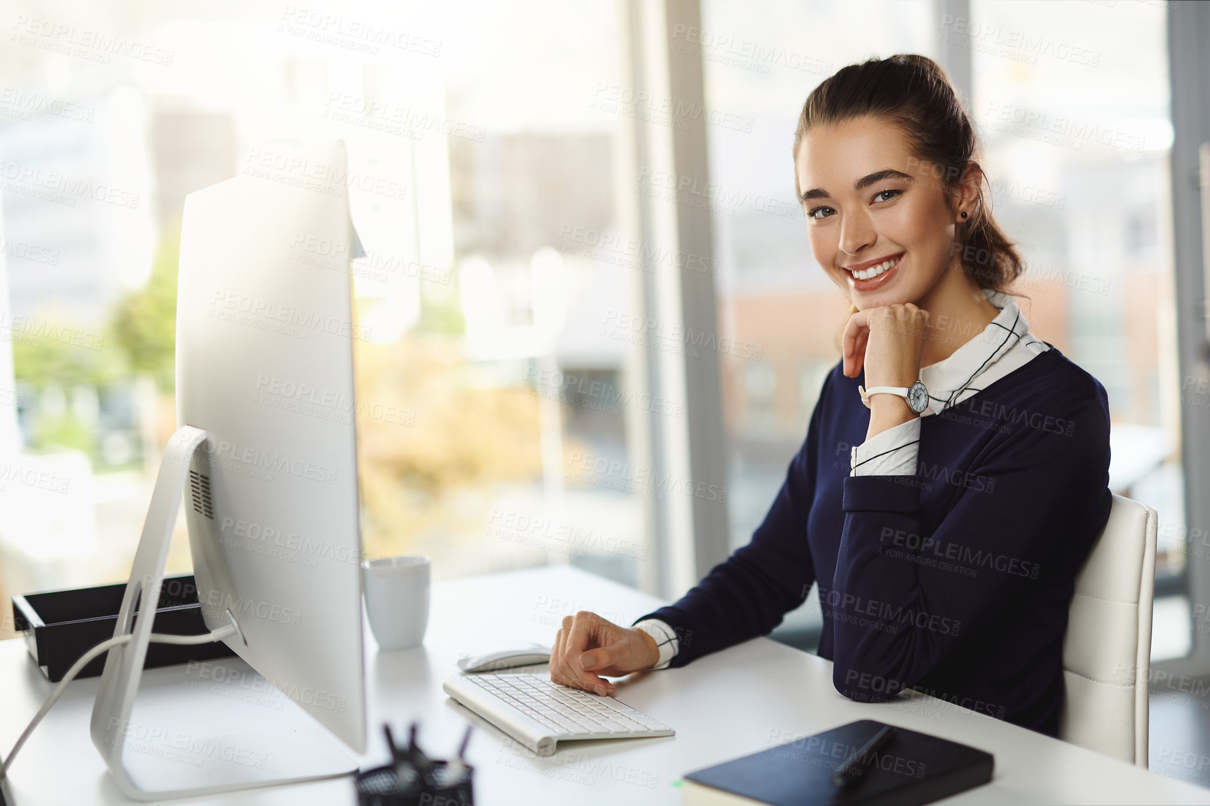 Buy stock photo Portrait of an attractive young businesswoman sitting at her desk and using her computer in a modern office