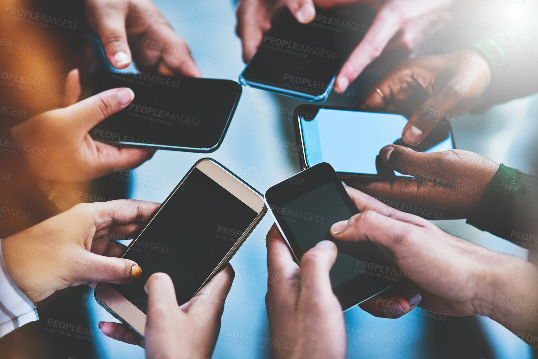 Buy stock photo Cropped shot of a group of people using their phones together