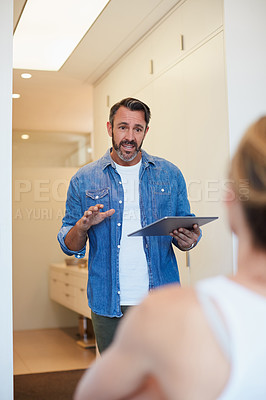 Buy stock photo Cropped shot of an attractive mature man talking to his wife while holding a digital tablet